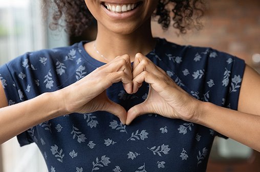 Woman making a heart with her hands while smiling